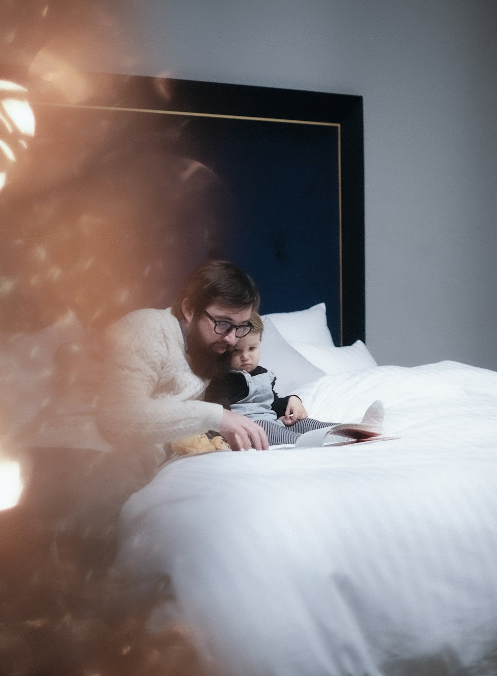 man in black suit lying on bed beside woman in white long sleeve shirt