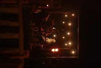 A cozy stage with three musicians playing guitars and singing passionately under warm lights.