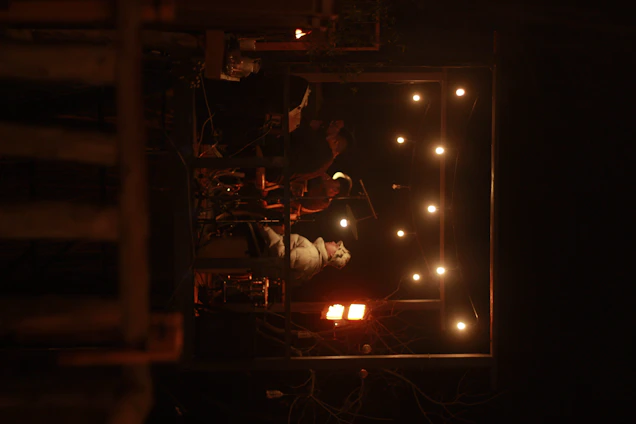 Rustic stage setting with TK Shoals performing under warm amber lights, acoustic guitars in hand.