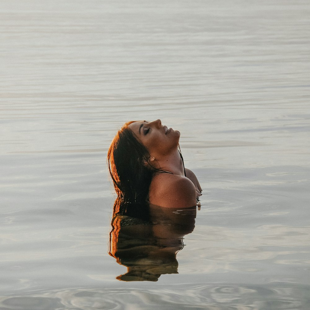 woman in black bikini top on water during daytime