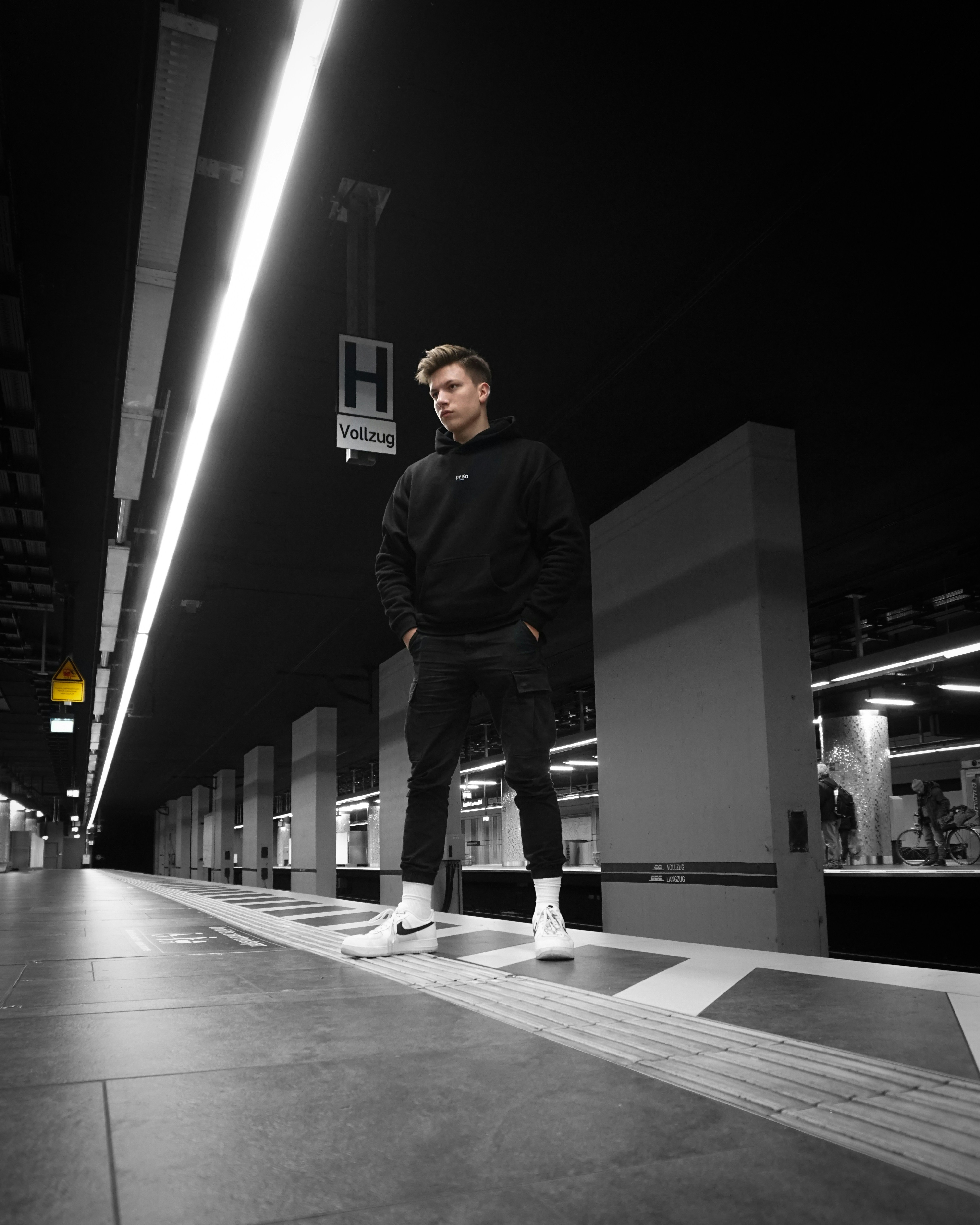 Mann in schwarzer Jacke auf dem Boden stehend