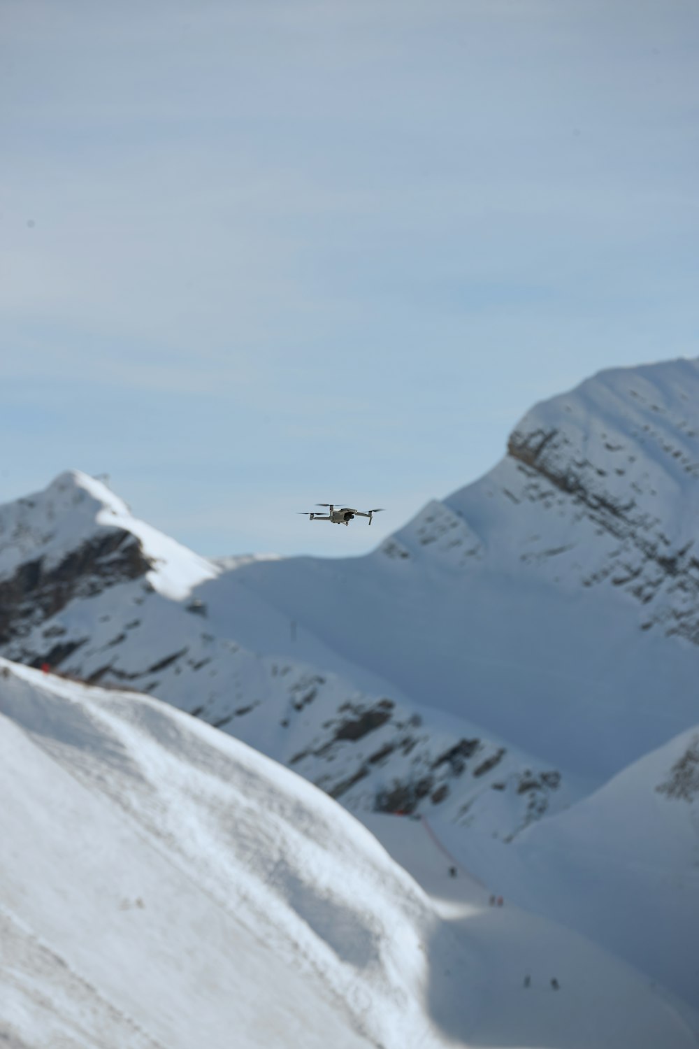 birds flying over snow covered mountain during daytime