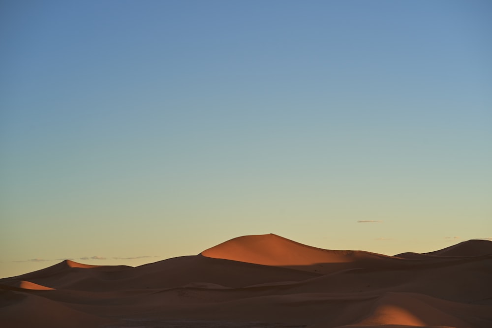 sable brun sous le ciel bleu pendant la journée