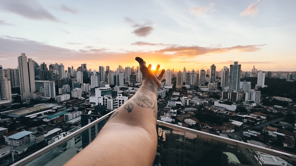 person lying on the roof top during sunset