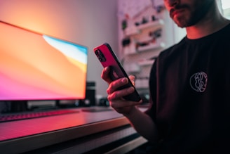 man in black suit jacket holding iphone