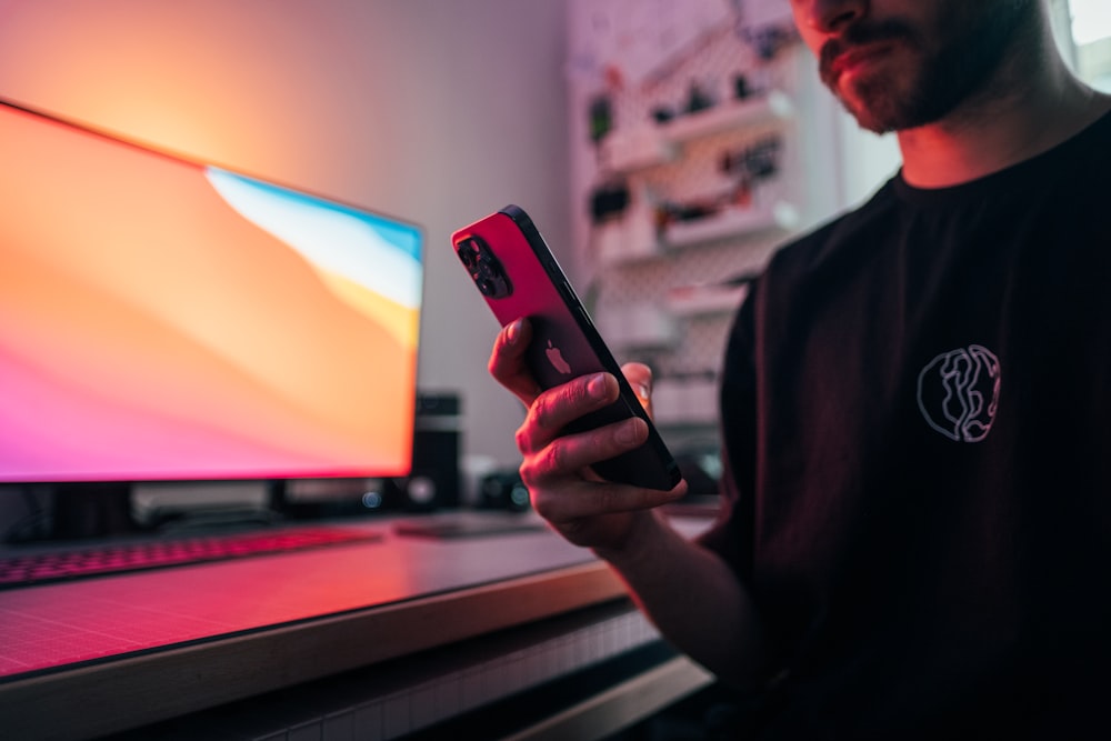 man in black suit jacket holding iphone