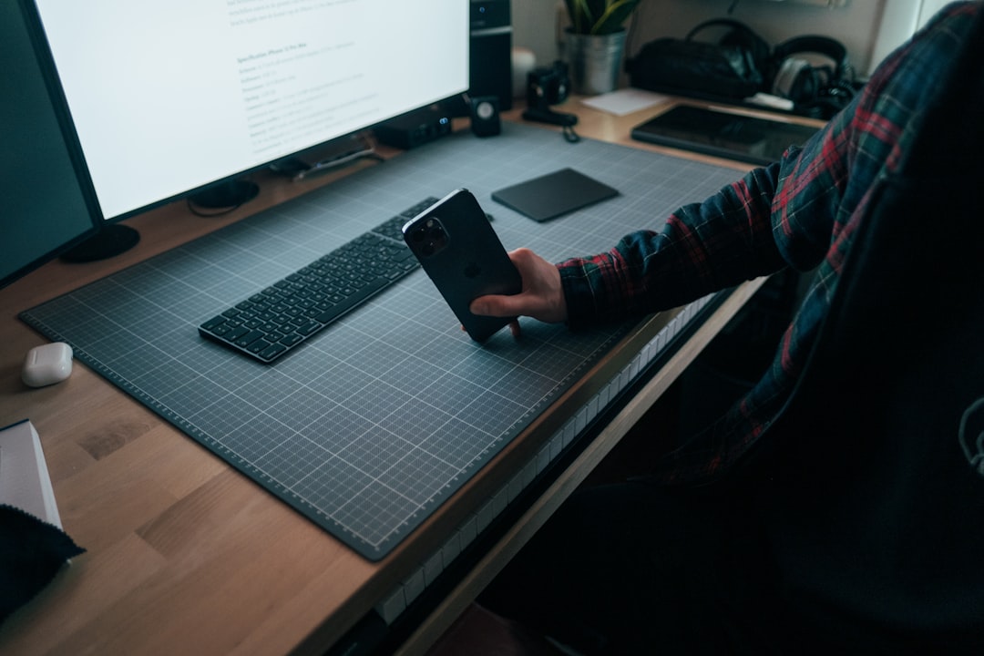 person in red and black long sleeve shirt holding black smartphone