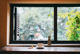 A peaceful morning scene with a cup of herbal tea on a wooden table near a window with soft sunlight.
