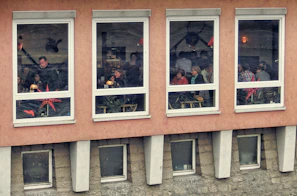 Members sharing stories inside a warmly lit cabin with frosted windows.
