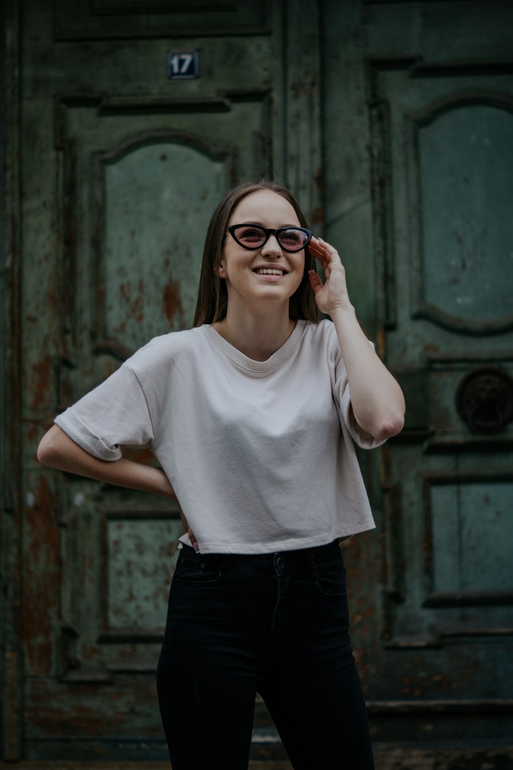 woman in white crew neck t-shirt and black pants wearing red framed eyeglasses