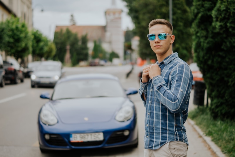 Sunglassed man by blue car