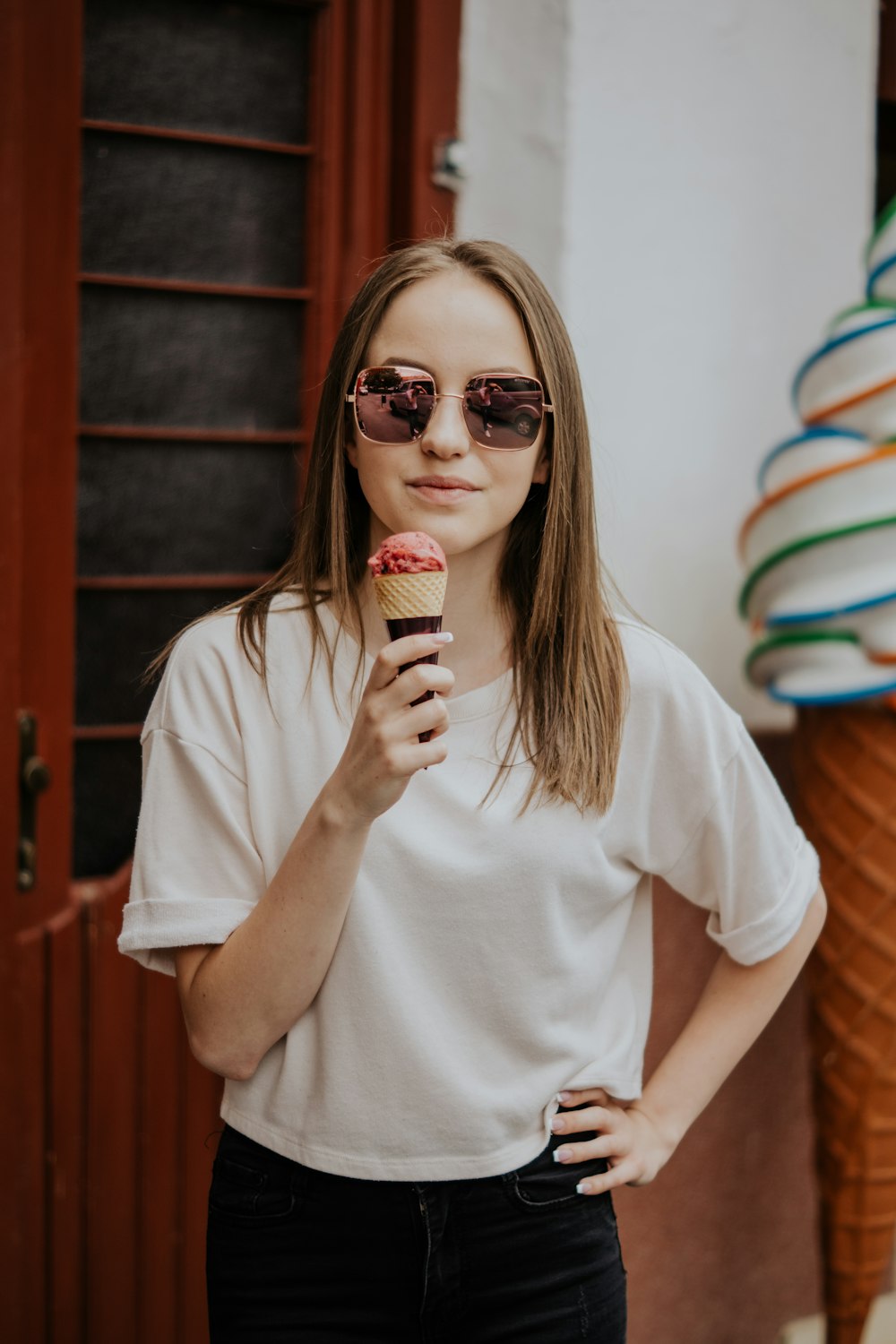 Foto mujer en camiseta blanca con cuello redondo sosteniendo cono de helado  – Imagen Humano gratis en Unsplash