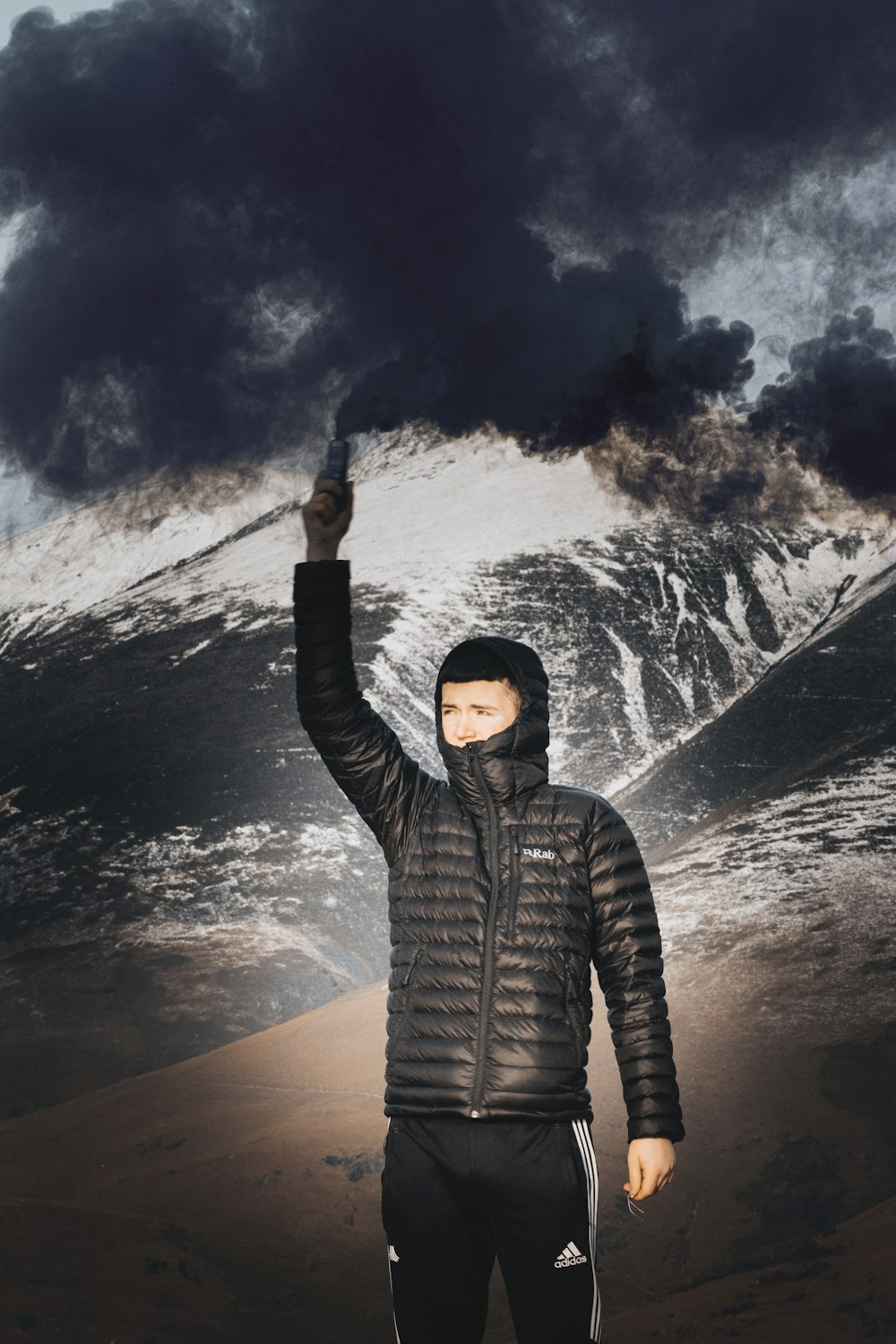 man in black and gray striped hoodie standing on snow covered ground during night time