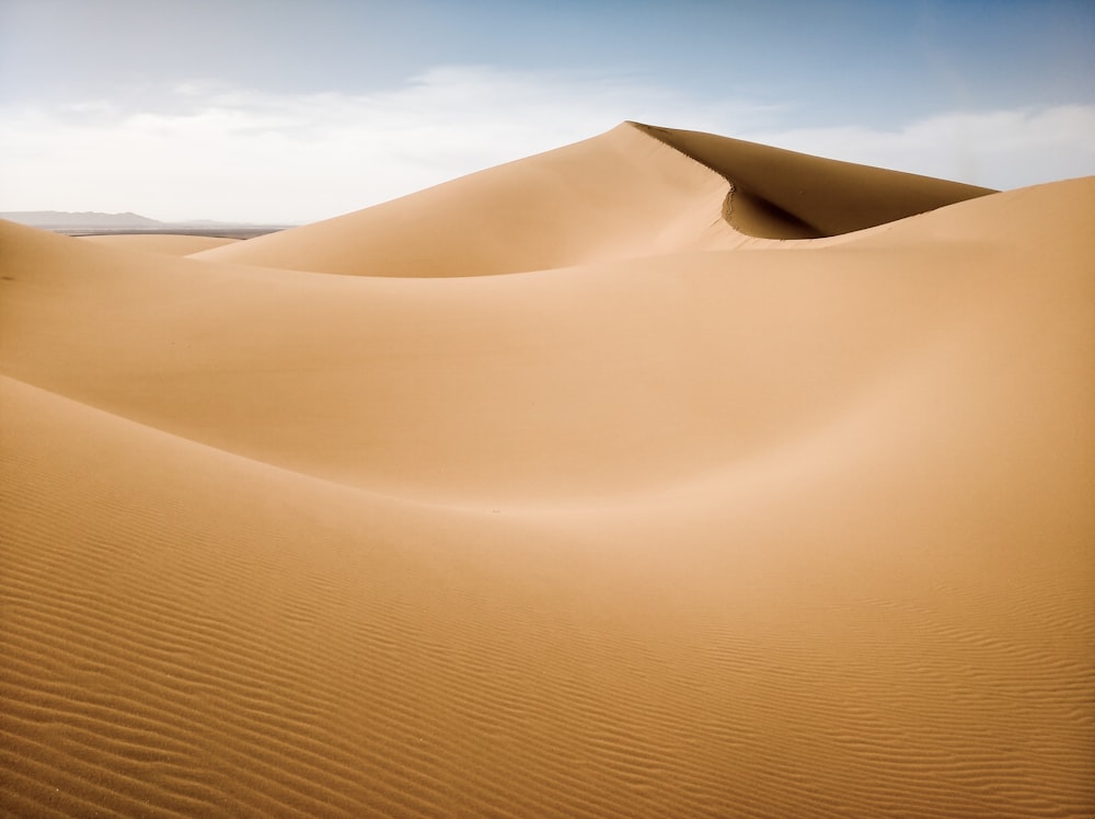 sable brun sous le ciel bleu pendant la journée