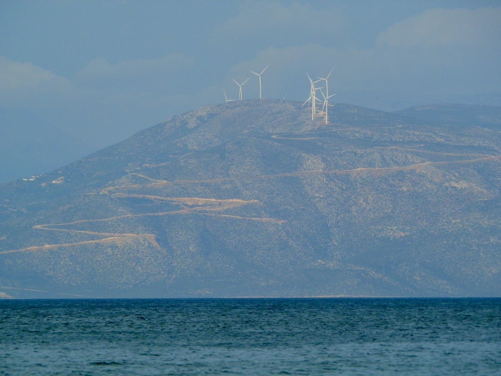 barca a vela bianca sul mare vicino alla montagna durante il giorno