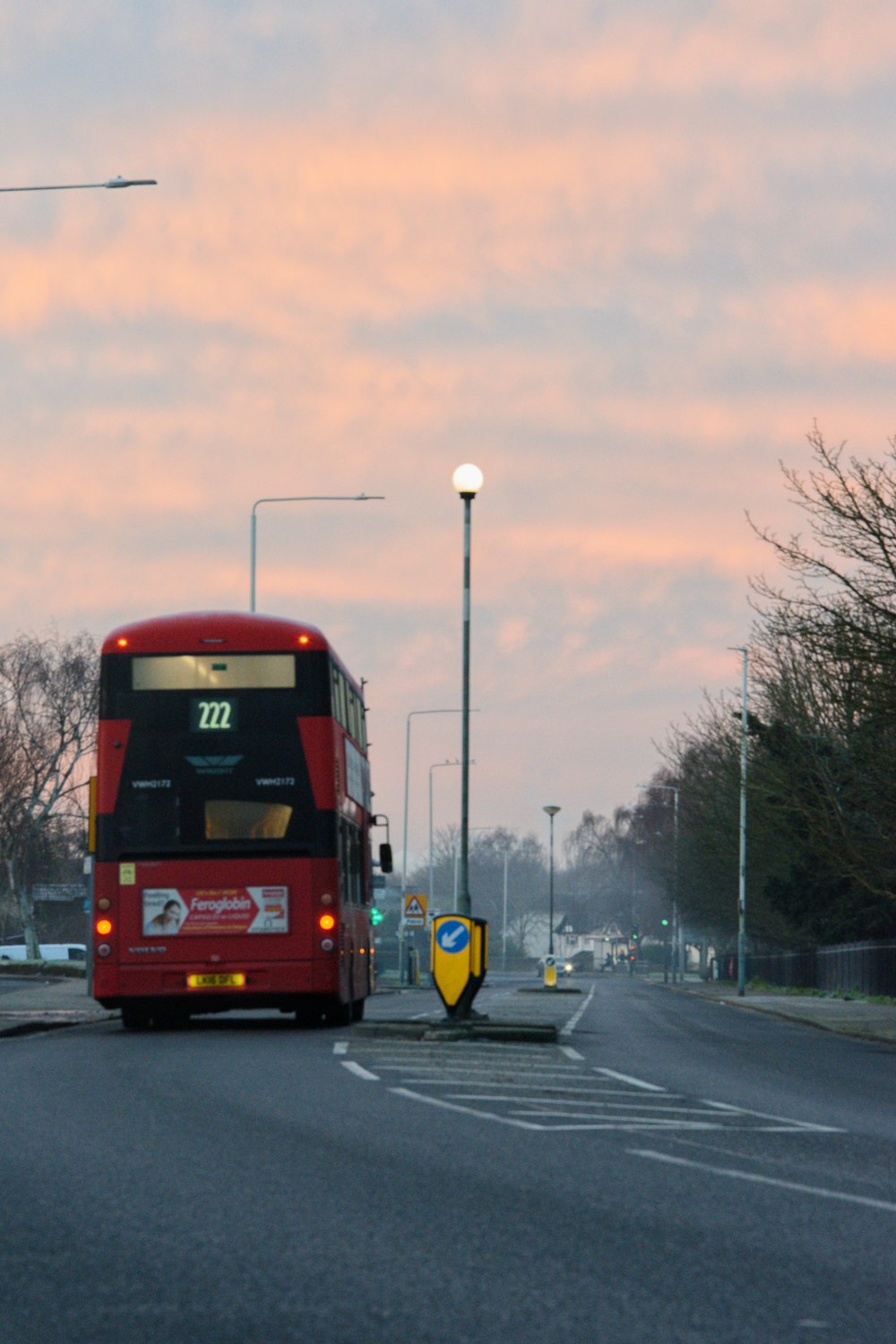 昼間の道路を走る赤と黒のバス