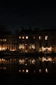 Night view of Navigli canals from apartment window, lights reflecting on water.
