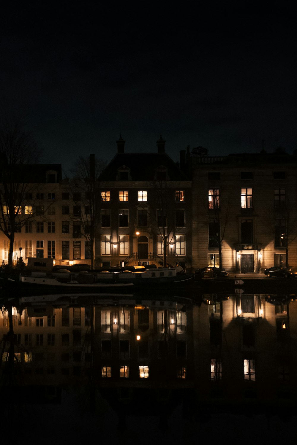 beleuchtetes Gebäude in der Nähe von Gewässern während der Nachtzeit