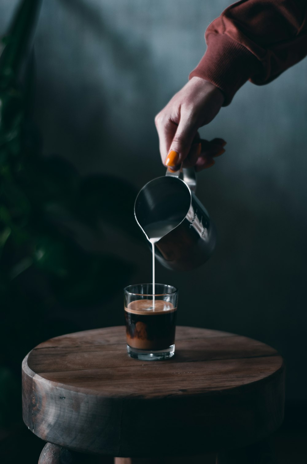 person pouring water on clear drinking glass