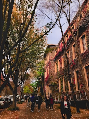 A group of Colombian students walking on a European university campus during autumn.