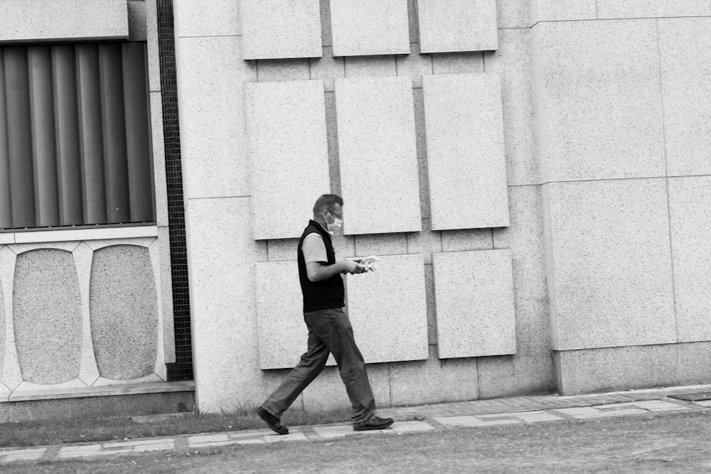 woman in black tank top and black pants standing on sidewalk during daytime