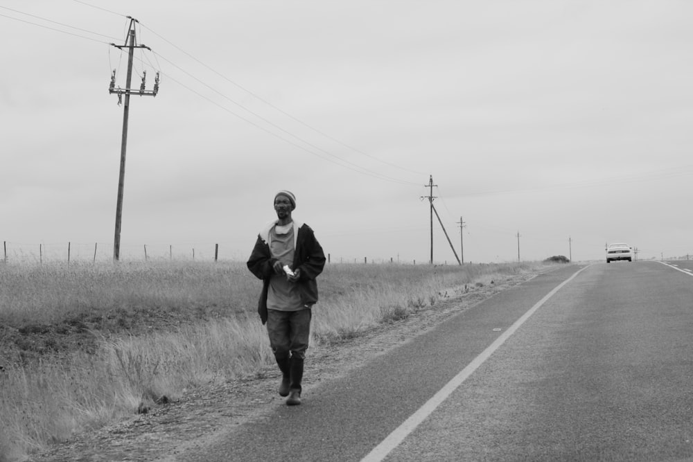 man in black jacket standing on road