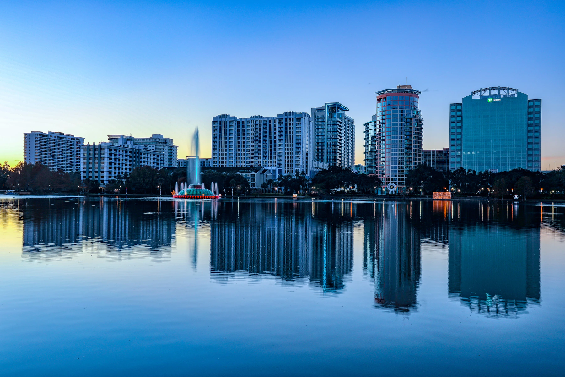 Downtown Orlando skyline reflected across Lake Eola at dusk