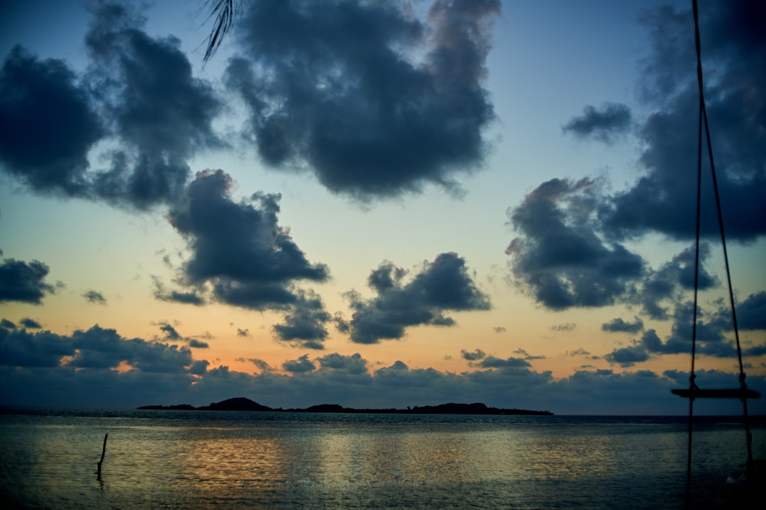 body of water under cloudy sky during sunset