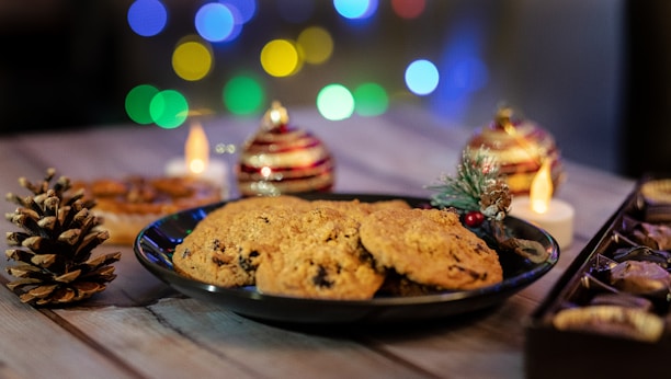 A colorful display of homemade Christmas cookies arranged on a festive table with twinkling lights.