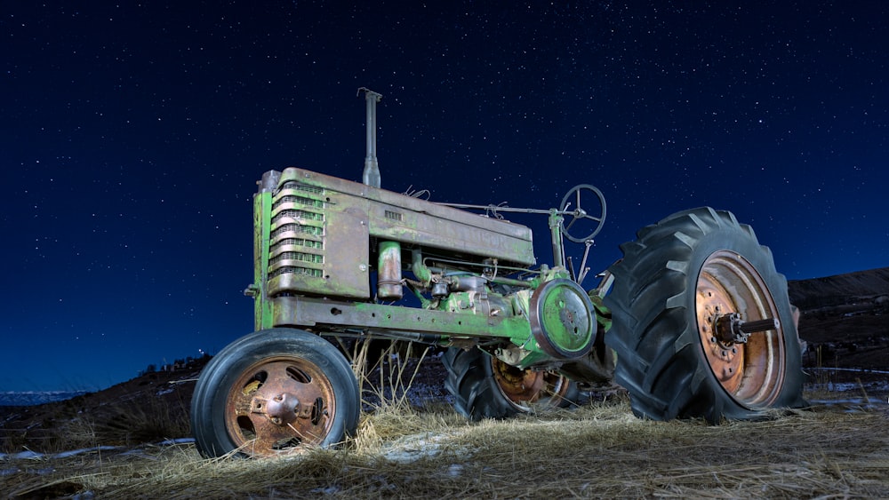 tracteur vert sur une friche industrielle pendant la nuit