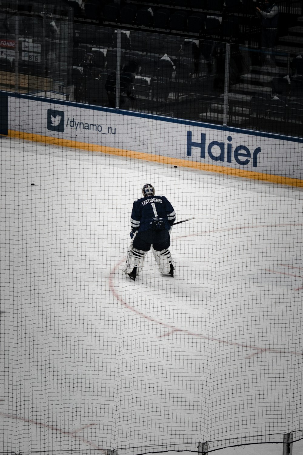 hombre en camisa de hockey sobre hielo blanco y negro montado en palo de hockey blanco y negro