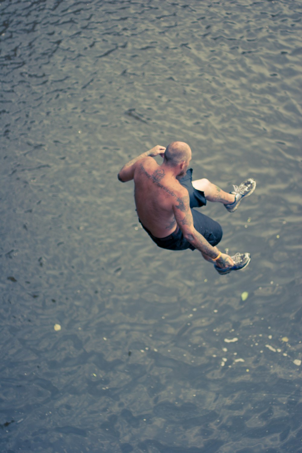 man in black shorts running on water during daytime