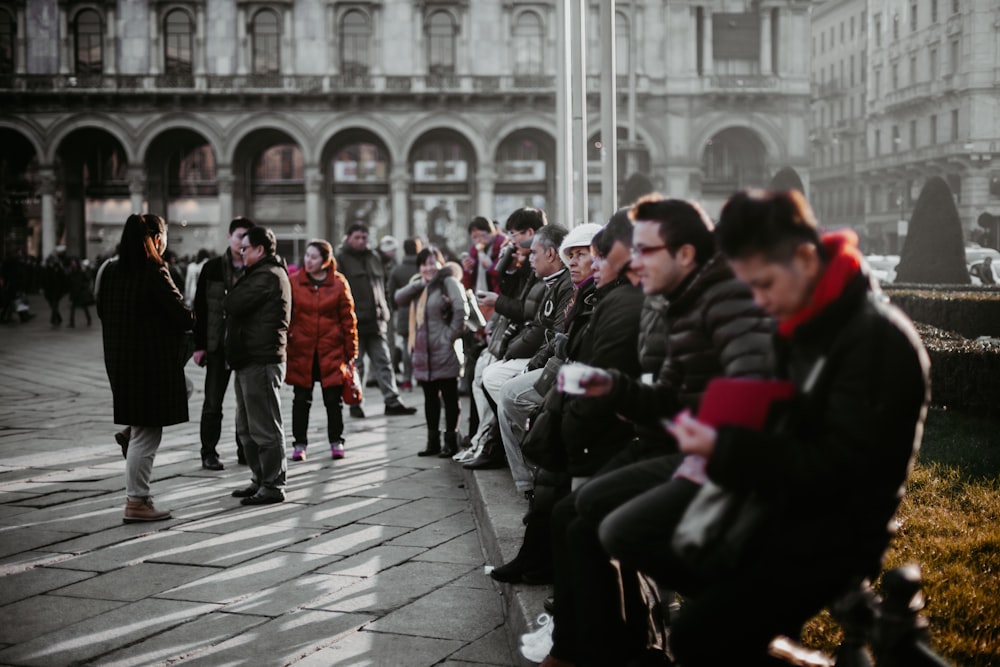 people sitting on bench in front of building