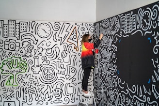 woman in black pants and orange jacket standing beside wall with graffiti