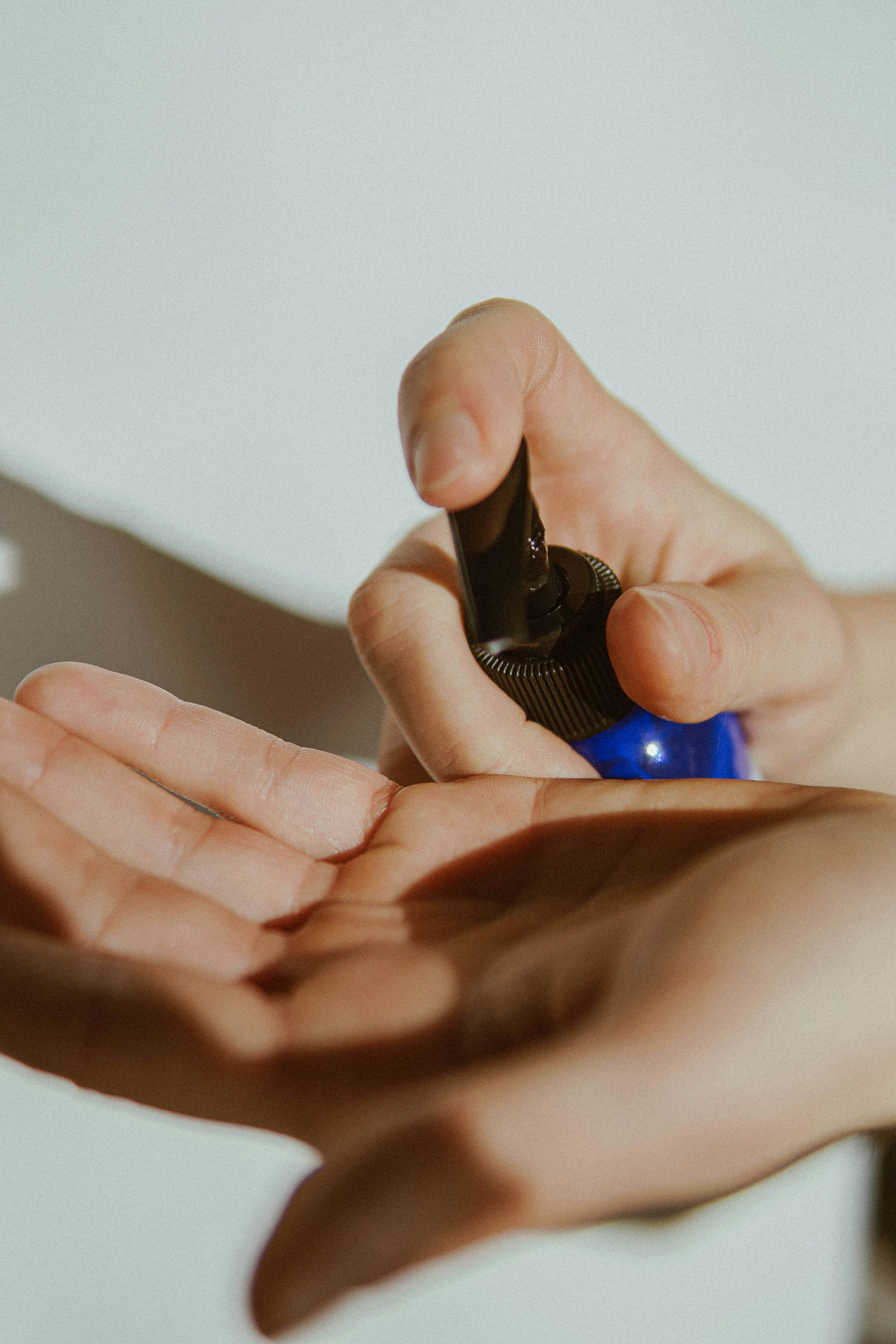 person holding mens hair styling product in left hand