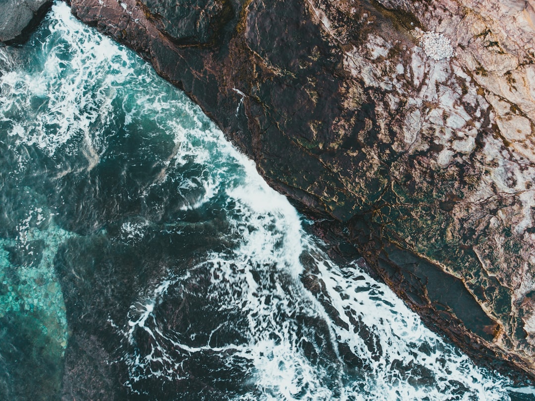 water waves hitting rocky shore during daytime