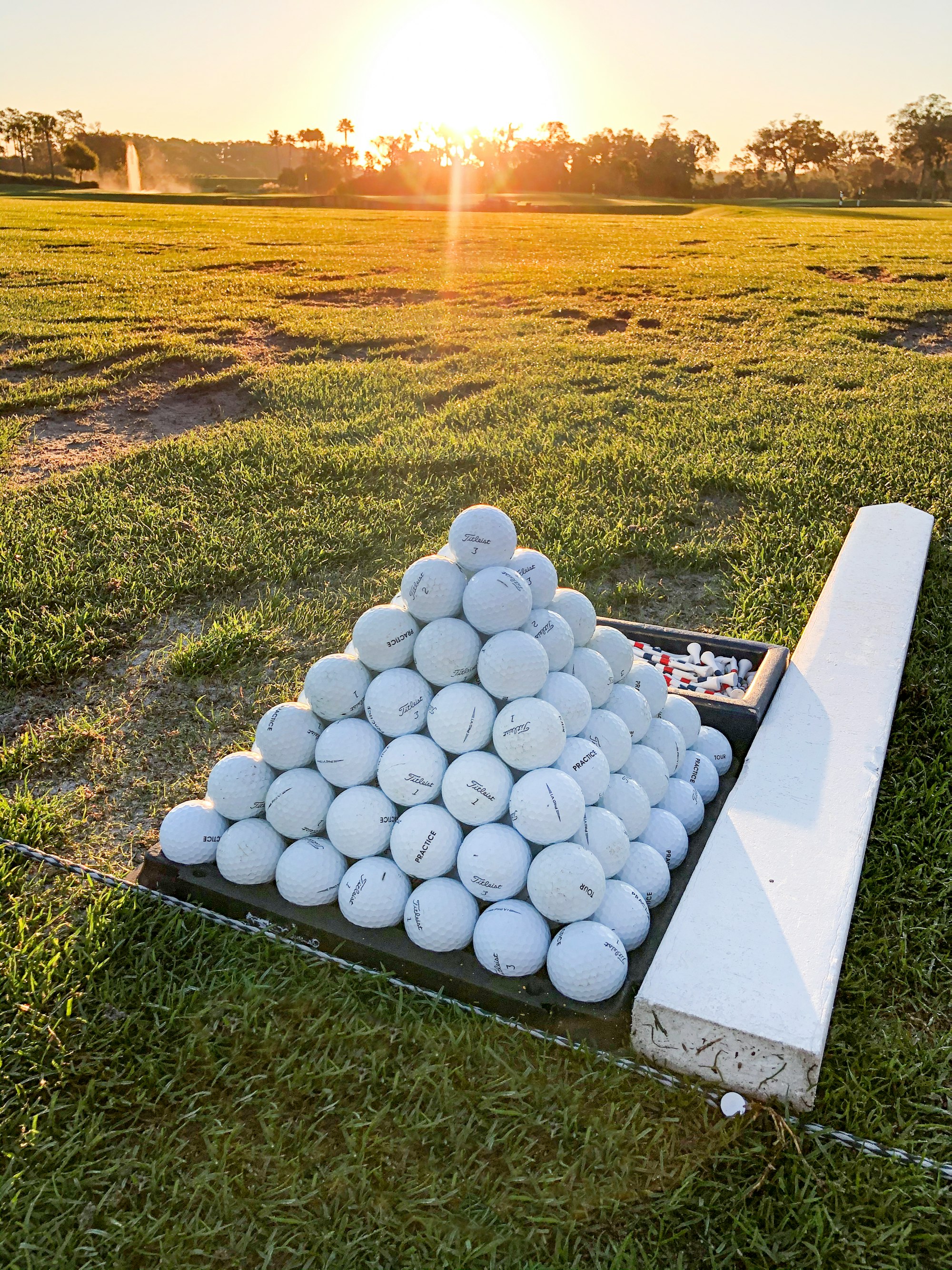 golf balls stacked up on the driving range