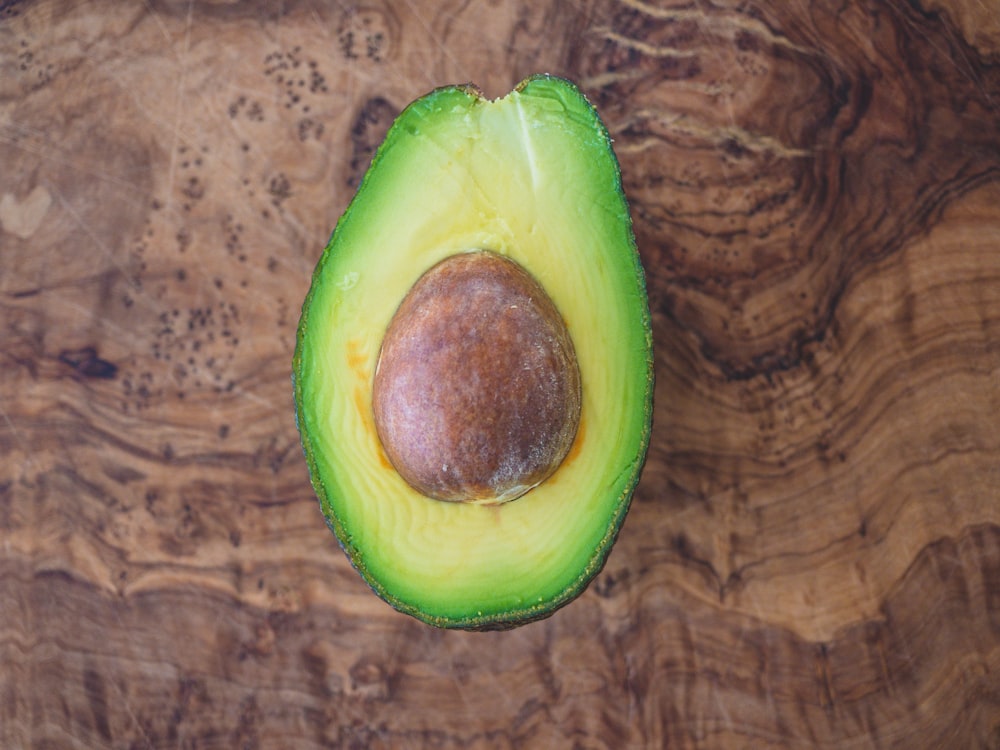 geschnittene Avocadofrüchte auf braunem Holztisch