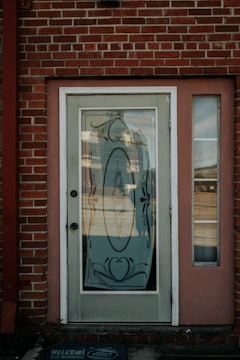 Residential front door with new glass panel shining in sunlight.