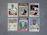 A collection of six vintage baseball cards featuring players from different teams, neatly arranged on a gray surface. Each card displays a portrait or action shot of a player, along with their team name and position.