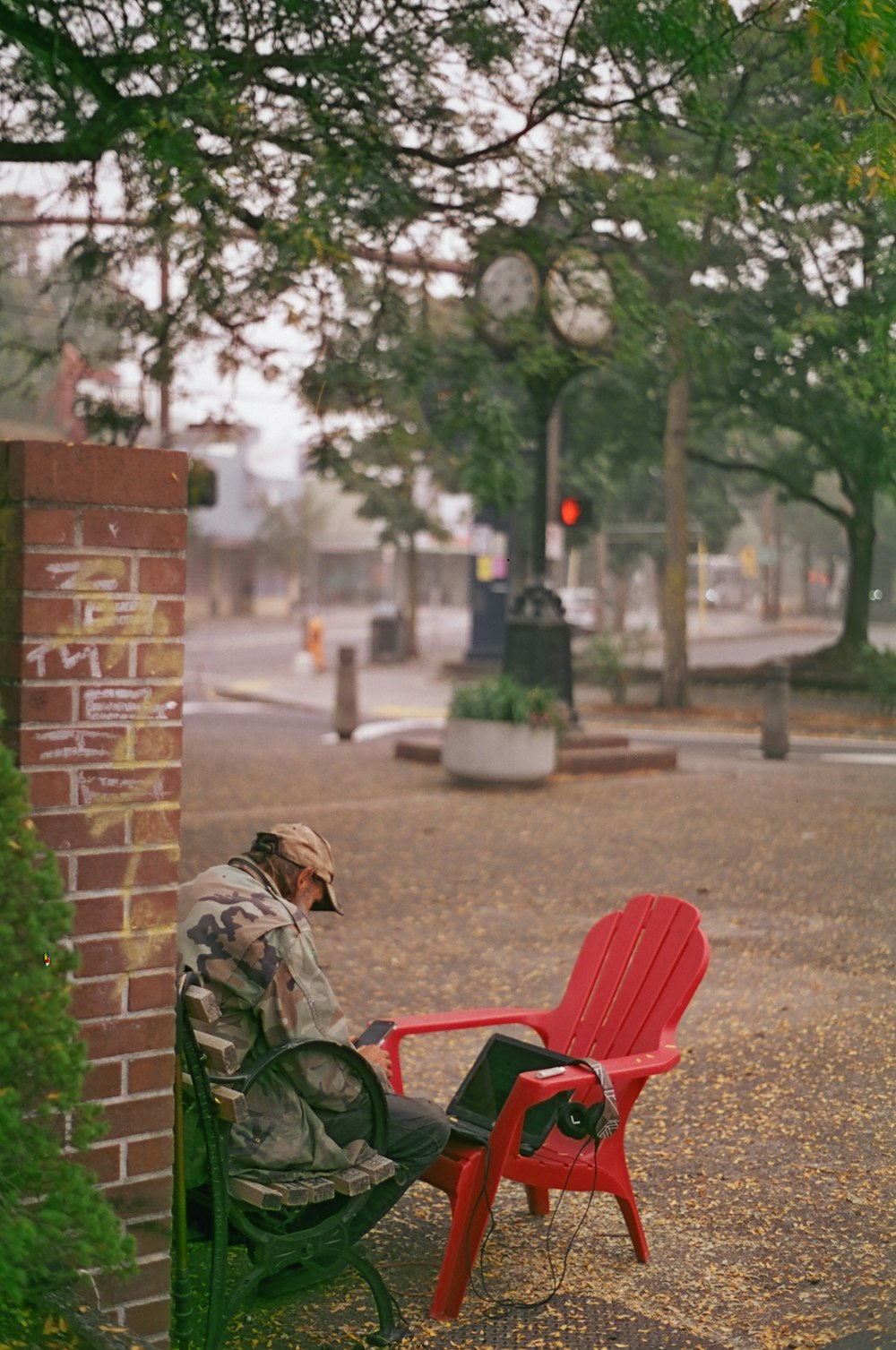man in green jacket sitting on red bench