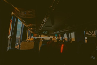 A happy passenger stepping into a clean, modern Buzcab vehicle at sunset.