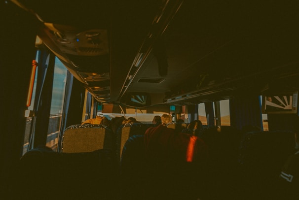 A happy passenger stepping into a clean, modern Buzcab vehicle at sunset.