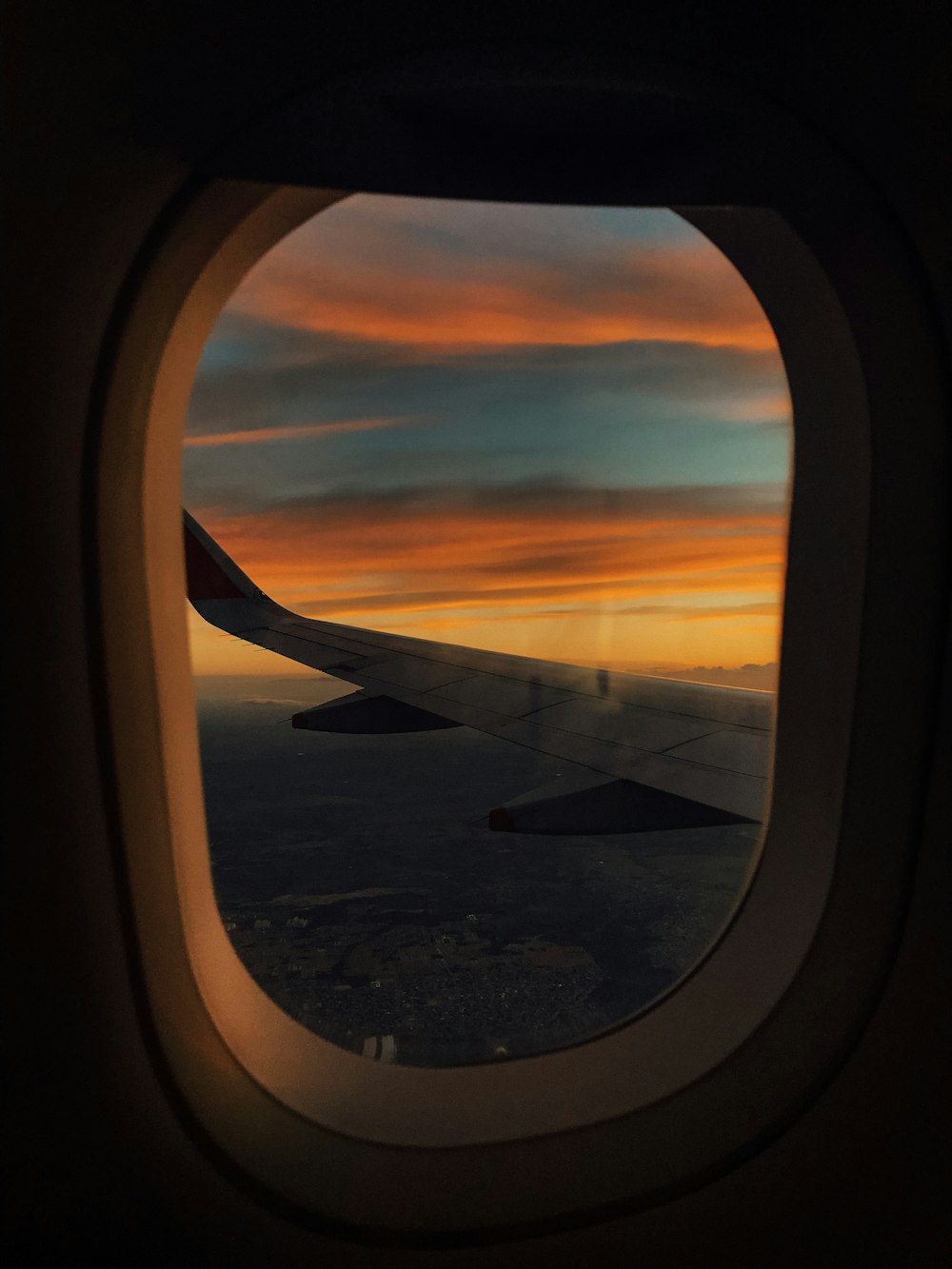 Vue de fenêtre d’avion sur les nuages au coucher du soleil