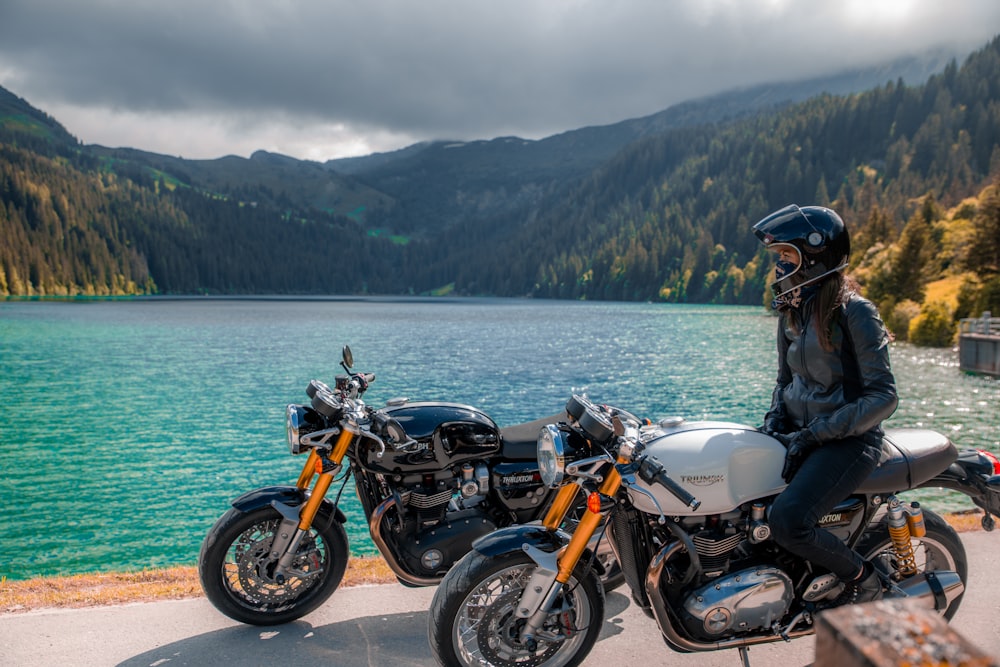 schwarz-orangefarbenes Motorrad in der Nähe des Gewässers tagsüber