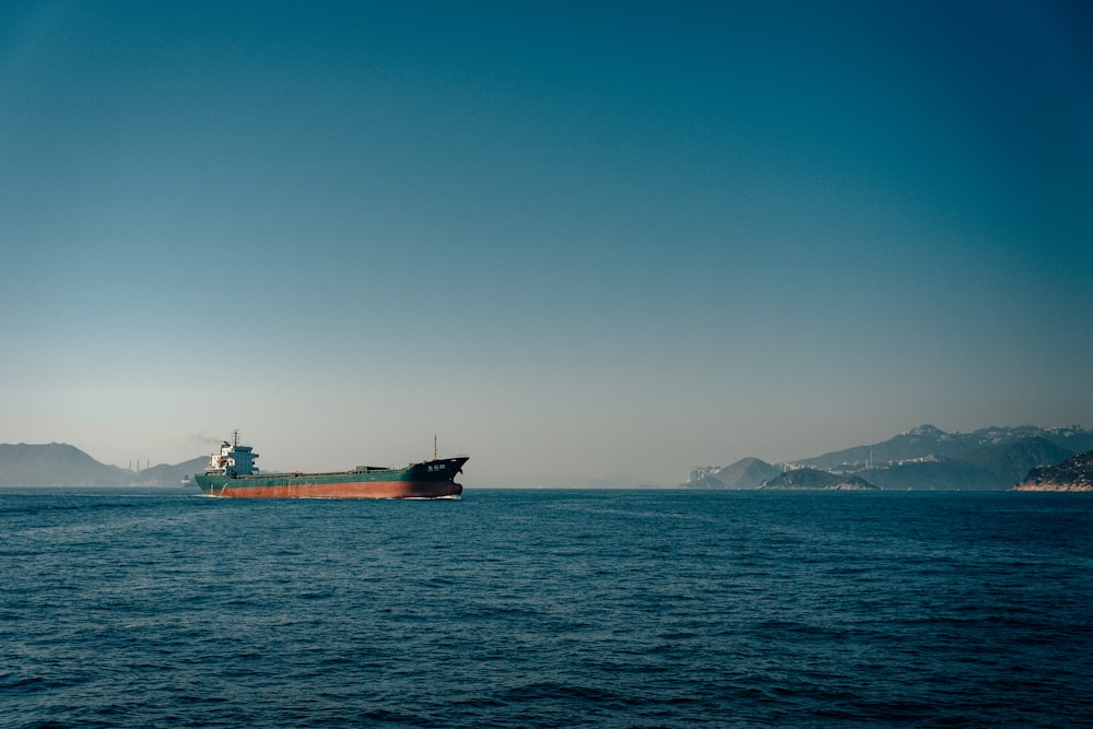 red ship on sea under blue sky during daytime