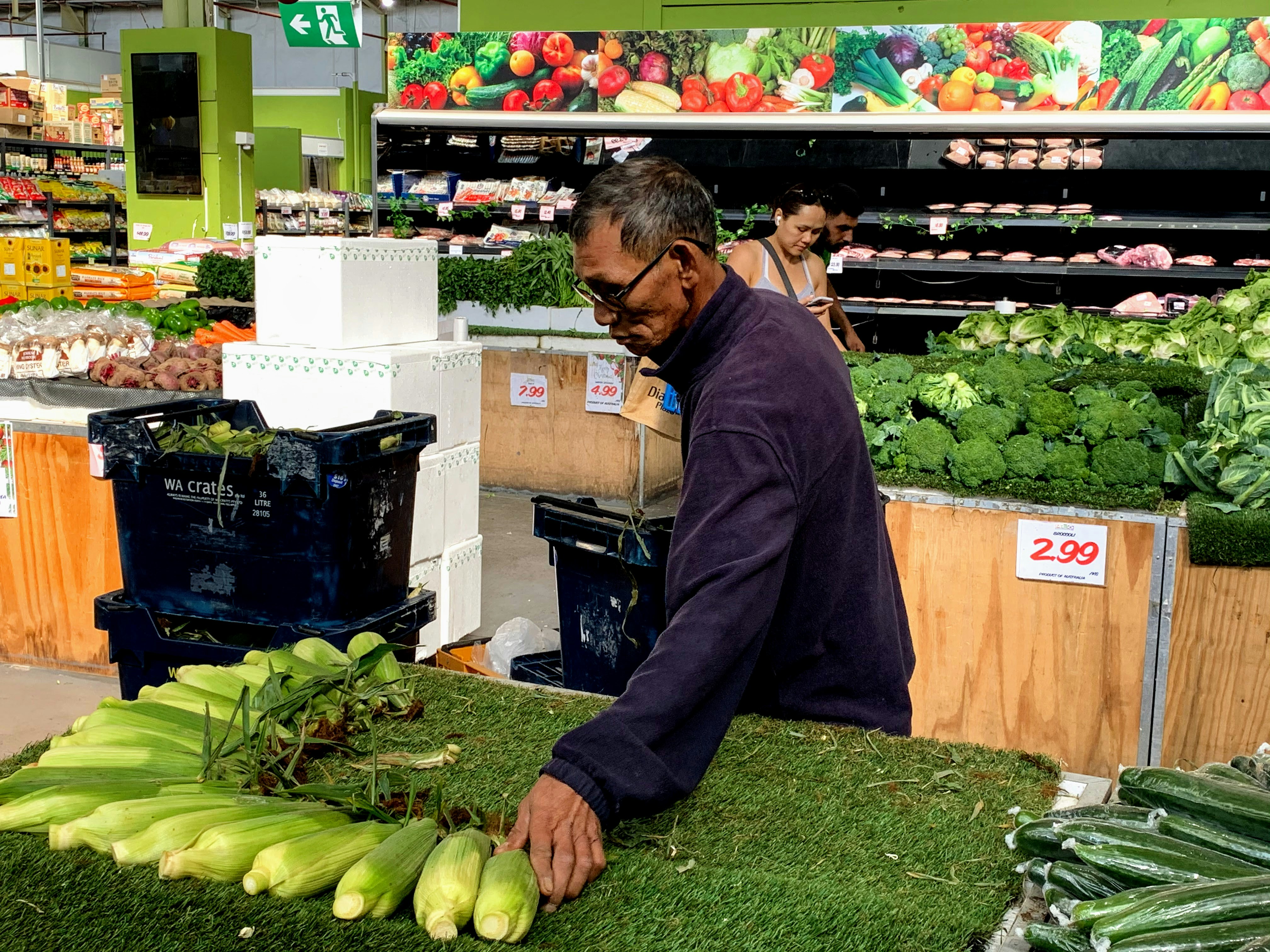 man in black jacket holding green vegetable