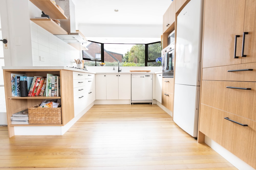 white dishwasher beside brown wooden kitchen cabinet