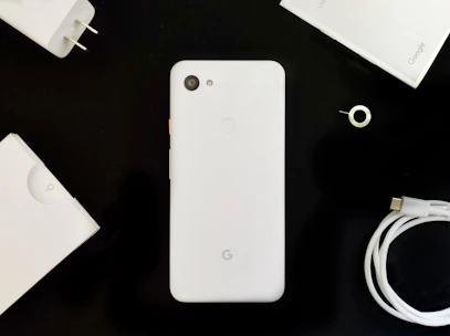 A sleek smartphone with colorful accessories neatly arranged on a white background.