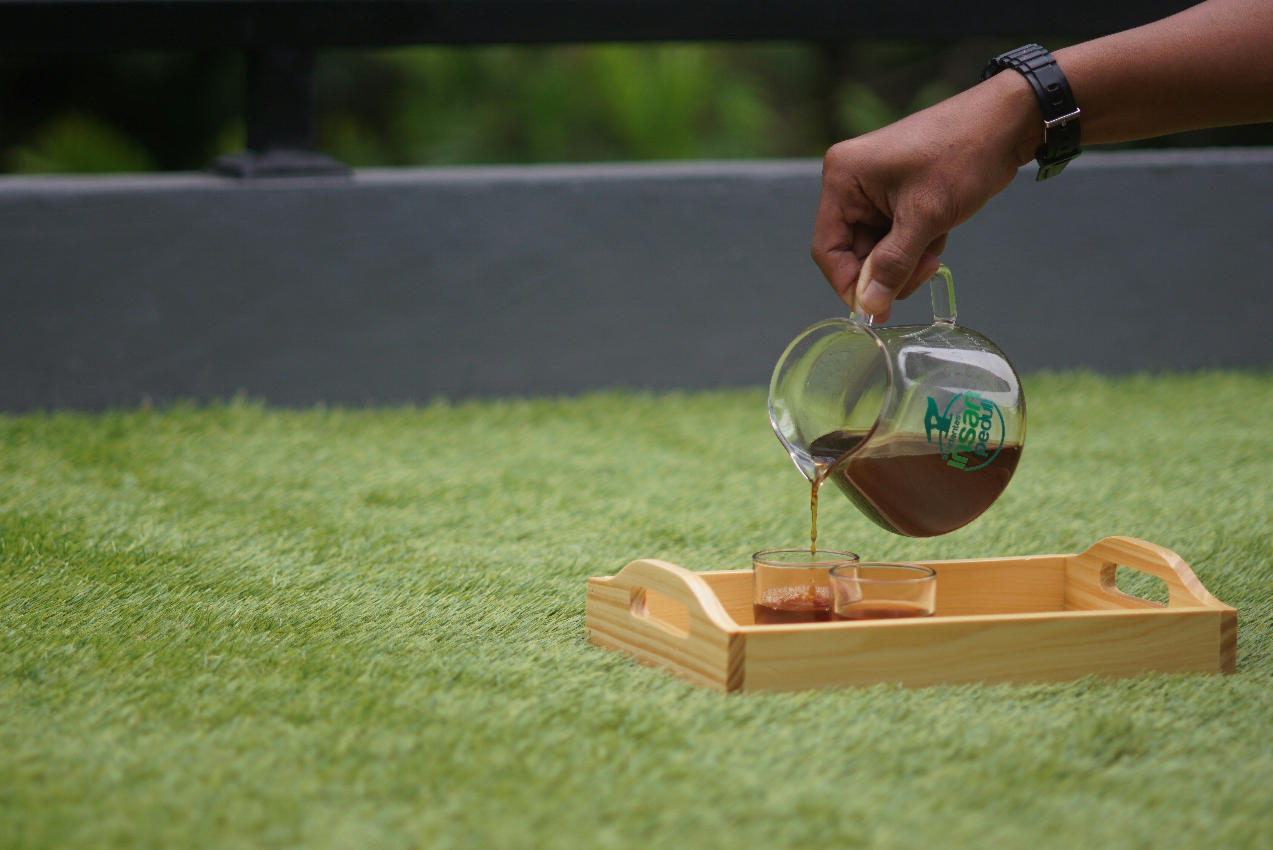 person holding clear glass bottle with brown wooden frame